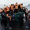 Người tị nạn và di cư tới đảo Lesbos, Hy Lạp sau cuộc hành trình vượt biển Aegean, Thổ Nhĩ Kỳ. (Nguồn: AFP/TTXVN)