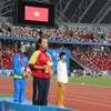 Vận động viên Lại Thị Ngọc Ánh (áo đỏ) hát quốc ca trong lễ trao giải. (Ảnh: Lê Hải-Việt Hải/TTXVN​)