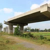 Cầu vượt qua Quốc lộ xuyên Á của đường Hồ Chí Minh xây dựng dở dang, bị bỏ hoang phế. (Ảnh: Lê Đức Hoảnh/TTXVN)