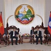 Thủ tướng Lào Thongsing Thamavong (phải) tiếp thân mật Bộ trưởng Hà Hùng Cường. (Ảnh: Phạm Kiên/TTXVN)
