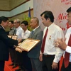 Ông Nguyễn Trác Toàn tặng Bằng khen cho đại diện tập thể, cá nhân đạt thành tích xuất sắc trong công tác xây dựng cộng đồng. (Ảnh: Xuân Khu/Vietnam+)