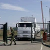 Một binh sỹ mở cửa biên giới để các xe tải chở hàng viện trợ vào Ukraine. (Nguồn: AP)