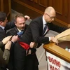Ông Oleg Barna tặng một bó hoa rồi tìm cách bế Thủ tướng Arseny Yatsenyuk khỏi bục phát biểu trước Quốc hội. (Nguồn: kyivpost.com)