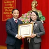 Phó Tổng Giám đốc TTXVN Lê Duy Truyền trao Kỷ niệm chương “Vì sự nghiệp thông tấn” cho Phó Trưởng Ban Chỉ đạo Tây Bắc Hoàng Thị Hạnh. (Ảnh: Thế Duyệt/TTXVN)