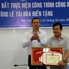 Phó Chủ tịch tỉnh Tây Ninh Dương Văn Thắng (trái) tặng Bằng khen của Ủy ban Nhân dân tỉnh cho ông Lê Tài Hòa. (Ảnh: Lê Đức Hoảnh/TTXVN)
