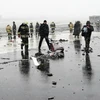 Lực lượng chức năng điều tra tại hiện trường ngổn ngang mảnh vỡ máy bay sau vụ tai nạn tại Rostov-on-Don. (Nguồn: AFP/TTXVN)
