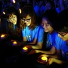 Các tình nguyện viên tại Thành phố Hồ Chí Minh thắp đèn led, hưởng ứng chiến dịch Giờ Trái đất Xanh (Ảnh: Mạnh Linh/TTXVN)