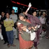 Chuyển một em nhỏ bị thương khỏi hiện trường vụ nổ bom. (Nguồn: AFP/TTXVN)