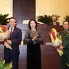 Chủ tịch Quốc hội Nguyễn Thị Kim Ngân tặng hoa chúc mừng hai Phó Chủ tịch Quốc hội mới. (Ảnh: Phương Hoa/TTXVN)