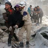 Lực lượng phòng vệ dân sự Syria sơ tán người bị thương khỏi hiện trường một vụ không kích tại Hayy Aqyul, thành phố Aleppo ngày 22/4. (Nguồn: AFP/TTXVN)