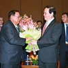 Chủ tịch Hội Hữu nghị Việt Nam-Lào Vũ Trọng Kim tặng hoa Tổng Bí thư, Chủ tịch nước Lào. (Ảnh: Doãn Tấn/TTXVN)