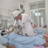 Bác sỹ Hoàng khám chữa bệnh cho bệnh nhân. (Ảnh: Trịnh Duy Hưng/Vietnam+)