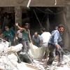 Lực lượng dân phòng Syria làm nhiệm vụ tại khu vực đổ nát sau một vụ tấn công ở Sukkari, vùng lân cận phía Bắc thành phố Allepo. (Nguồn: AFP/TTXVN) 