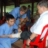 Các bác sỹ và sinh viên Trường Đại học Mercer lắp ráp chân giả cho bệnh nhân. (Ảnh: Nguyễn Văn Việt/TTXVN)