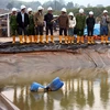 Cán bộ và công an môi trường tỉnh Quảng Nam kiểm tra hồ chứa nước thải của Nhà máy vàng Bồng Miêu. (Ảnh: Trần Tĩnh/TTXVN)