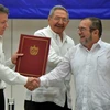 Tổng thống Colombia Juan Manuel Santos (trái) và thủ lĩnh FARC Timoleon Jimenez (phải) trong lễ ký thỏa thuận ngừng bắn vĩnh viễn dưới sự chứng kiến của Chủ tịch Cuba Raul Castro. (Nguồn: AFP/TTXVN)
