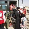 Nhân viên Hội Trăng lưỡi liềm Đỏ Syria hỗ trợ người dân sơ tán khỏi Daraya tới trại tị nạn Herjelleh ở gần Damascus. (Nguồn: EPA/TTXVN)