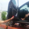 Chiếc xe ôtô và nữ tài xế cố thủ trong xe bị đưa về Trạm kiểm soát giao thông Ngã ba Thái Lan. (Ảnh: Sỹ Tuyên/TTXVN)