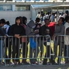 Người di cư xếp hàng nhận lương thực cứu trợ tại Calais, Pháp. (Nguồn: AFP/TTXVN)