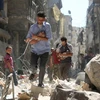 Chuyển các em nhỏ Syria ra khỏi một tòa nhà bị sập sau vụ không kích nhằm vào khu vực Salihin ở thành phố Aleppo, miền bắc Syria ngày 11/9. (Nguồn: AFP/TTXVN)