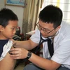 Bác sỹ Bệnh viện Việt Đức khám sàng lọc bệnh tim cho trẻ dưới 16 tuổi. (Ảnh: Hoàng Ngà/TTXVN)