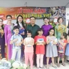 Đại sứ Phạm Cao Phong tặng sách cho các học sinh của lớp học. (Ảnh: Hoàng Nhương/Vietnam+)