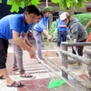 Lực lượng đoàn thanh niên Thạch Hà giúp Trường Mầm non Thạch Đài vệ sinh sân trường. (Ảnh: Công Tường/TTXVN)