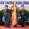 Chủ tịch nước Trần Đại Quang gắn Huân chương Quân công hạng Nhất lên lá cờ truyền thống của lực lượng vũ trang Thủ đô. (Ảnh: Nhan Sáng/TTXVN)