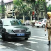 Cảnh sát giao thông ra hiệu lệnh dừng xe biển xanh trên phố Trần Phú, Hà Nội. (Ảnh: Doãn Tấn/TTXVN)