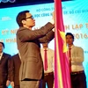 Phó Thủ tướng Vũ Đức Đam gắn Huân chương Độc lập Hạng Ba lên cờ truyền thống của Trường Đại học Công nghiệp Thành phố Hồ Chí Minh. (Ảnh: Thế Anh/TTXVN)