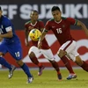 Cầu thủ Teerasil Dangda (trái), đội Thái Lan tranh bóng với các cầu thủ đội Indonesia. (Nguồn: AP/TTXVN)