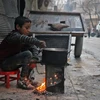 Một em bé Syria nấu ăn trên đường phố Aleppo. (Nguồn: AFP/TTXVN)