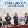Bí thư Thành ủy Hà Nội Hoàng Trung Hải tặng quà và kinh phí hỗ trợ Quỹ xóa đói giảm nghèo tỉnh Lào Cai. (Ảnh: Hương Thu/TTXVN)