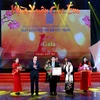 Bộ trưởng Bộ Lao động-Thương binh và Xã hội Đào Ngọc Dung trao tặng Bằng khen của Thủ tướng Chính phủ cho các tập thể, cá nhân có nhiều đóng góp cho Quỹ Bảo trợ Trẻ em Việt Nam. (Ảnh: Quang Quyết/TTXVN)
