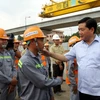 Bí thư Thành ủy Đinh La Thăng chúc Tết, động viên công nhân đang thi công công trình tại nút giao thông hoàn chỉnh, quận 9. (Ảnh: Thanh Vũ/TTXVN)