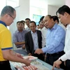 Thủ tướng Nguyễn Xuân Phúc thăm các gian hàng của các công ty trưng bày bên lề hội nghị. (Ảnh: Kim Há/TTXVN)