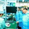 Thủ tướng Nguyễn Xuân Phúc thăm khu sản xuất của Công ty cổ phần Công nghệ công nghiệp Bưu chính viễn thông Việt Nam. (Ảnh: Thống Nhất/TTXVN)
