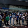 Người dân Venezuela xếp hàng chờ giao dịch bên ngoài Ngân hàng Trung ương ở Caracas. (Nguồn: EPA/TTXVN)