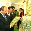 Thủ tướng Nguyễn Xuân Phúc thăm các gian hàng trưng bày sản phẩm tại hội nghị. (Ảnh: Thống Nhất/TTXVN)