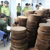 Lực lượng chức năng kiểm đếm số gỗ nghiến được sơ chế dạng thớt tại cơ sở chế biến gỗ và kinh doanh nội thất của ông Vũ Mạnh Hoạch. (Ảnh: Lê Lâm/TTXVN)