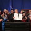 Tổng thống Donald Trump (giữa, phía trước) ký sắc lệnh hành pháp về việc tăng cường và xem xét chương trình thị thực H-1B. (Nguồn: AFP/TTXVN)