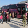 Xe buýt sơ tán người dân và các tay súng Syria dừng lại tại một điểm trung chuyển ở Rashidin. (Nguồn: AFP/TTXVN)