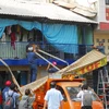 Lực lượng chức năng tiến hành tháo dỡ nhiều trường hợp nhà dân dựng mái che, biển hiệu chiếm vỉa hè đường Nguyễn Đình Chiểu (phường Đa Kao, quận 1). (Ảnh: Mạnh Linh/TTXVN)