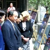 Các đại biểu tham quan triển lãm ảnh. (Ảnh: Trần Quang Vinh/Vietnam+)