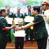 Đại tướng Ngô Xuân Lịch trao tặng Bằng khen cho các cá nhân, vì đã có nhiều thành tích trong công tác góp phần vào xây dựng sự nghiệp quân đội, củng cố quốc phòng và bảo vệ Tổ quốc. (Ảnh: An Đăng/TTXVN)