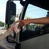 Lái xe sử dụng tiền lẻ mua vé qua trạm BOT tuyến tránh thành phố Biên Hòa. (Ảnh: Sỹ Tuyên/TTXVN)