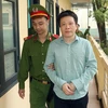 Cảnh sát dẫn giải bị cáo Hà Văn Thắm, nguyên Chủ tịch Hội đồng Quản trị Ngân hàng thương mại cổ phần Đại Dương. (Ảnh: Doãn Tấn/TTXVN)