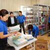 Đoàn viên thanh niên TTXVN chuyển sách lên giá tại thư viện trường Phổ thông Dân tộc bán trú Tiểu học và THCS Phình Hồ. (Ảnh: Thành Đạt/TTXVN)