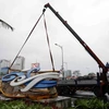 Các lực lương chức năng đang cẩu dọn cổng chào bằng sắt bị đổ tại Công viên biển Đông (Đà Nẵng). (Ảnh: Trần Lê Lâm/TTXVN)