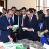 Thủ tướng Nguyễn Xuân Phúc thăm các gian hàng trưng bày sản phẩm. (Ảnh: Thống Nhất/TTXVN)